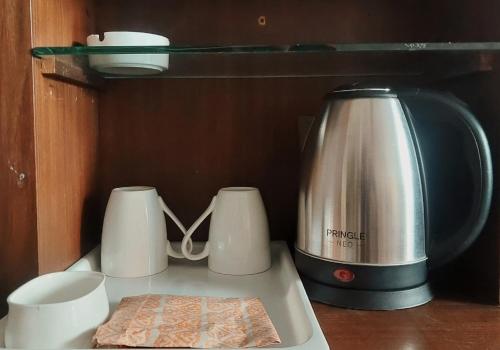 a toaster and two cups on a counter at Modi Hotel & Resorts in Pinjaur