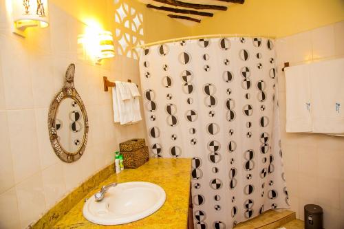 a bathroom with a sink and a shower curtain at 3 Bed Villa Sleeps 6 - Pool Garden Chef Option in Diani Beach