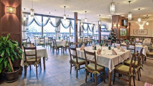 ein Speisesaal mit Tischen und Stühlen in einem Restaurant in der Unterkunft Pamporovo Central Apartments in Pamporowo