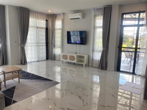a living room with a television and a large marble floor at Hillview Terrace in Hat Yai