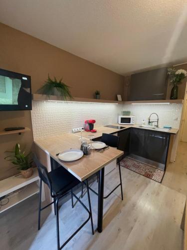 - une cuisine avec une table, des chaises et un évier dans l'établissement Studio cosy, à Balaruc-les-Bains