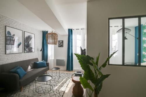 un salon avec un canapé et une plante dans l'établissement Promenade Best Bakeries from a Cozy Boho 1 Bedroom, à Paris
