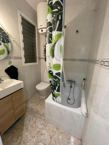 a bathroom with a tub and a toilet and a sink at Cosy apartment in Benicarló