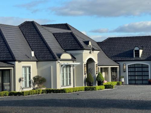 a white house with a black roof at Wake Up to Stunning Views - Luxury Counrty Escape by Scotch Hill Truffle Farm in Neerim South