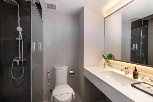 a bathroom with a toilet and a sink and a shower at Cross Vibe Bangkok Sukhumvit in Bangkok