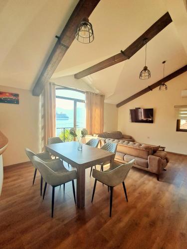 a living room with a table and chairs and a couch at Regina di Dobrota in Kotor