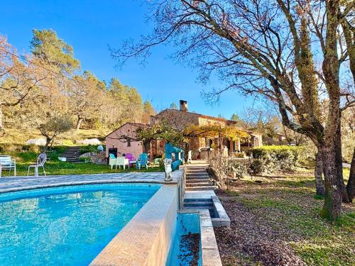 une maison avec une piscine devant une maison dans l'établissement La Caline, villa familiale au calme avec piscine, à Saint-Paul-en-Forêt