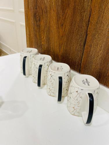 a group of four coffee cups sitting on a table at Goldcrest - 1 Bedroom Luxury Apartment - Lahore in Lahore