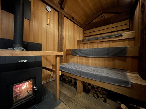 a sauna with a stove and a fireplace at Tiny Base in Kawazu