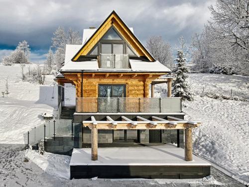 a log cabin in the snow with snow covered ground at Malczykówka-luksusowy dom & SPA, z widokiem na Tatry in Bukowina Tatrzańska