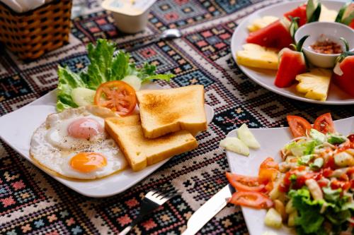 two plates of breakfast food on a table at Commander Lodge in Phong Nha