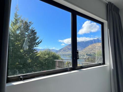 a window with a view of a mountain view at Spectacular Lake and Mountain Views Close to town in Queenstown