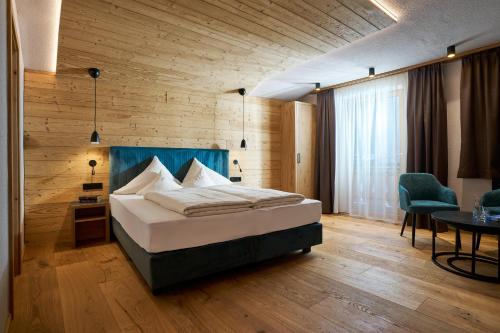 a bedroom with a bed and a table and a chair at Hotel Stern in Ehrwald