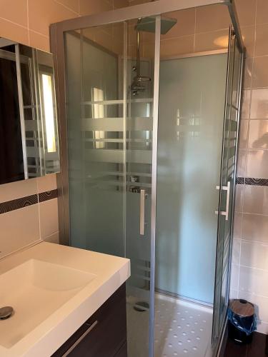 une douche en verre dans une salle de bain avec un lavabo dans l'établissement Bandol - Plage de Renécros, à Bandol