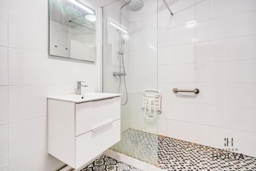 une salle de bain blanche avec un lavabo et une douche dans l'établissement Le Grandiose - Aux portes de Paris - 328B, à Levallois-Perret