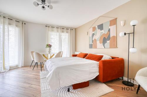 - une chambre avec un lit orange et une table dans l'établissement Le Grandiose - Aux portes de Paris - 328B, à Levallois-Perret
