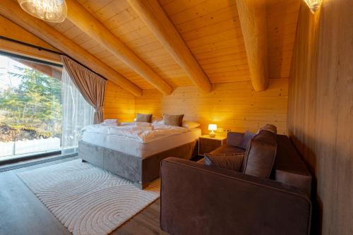 una camera da letto con un letto, due sedie e una finestra di Royal Chalet Donovaly a Donovaly