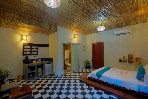 a bedroom with a bed and a checkered floor at Old Khmer House in Siem Reap