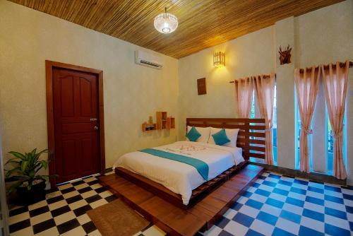 a bedroom with a bed and a checkered floor at Old Khmer House in Siem Reap
