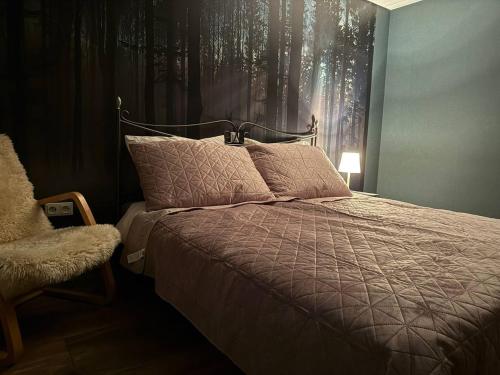 a bedroom with a bed with a blanket and a chair at Voll ausgestattete, helle Ferienwohnung auf 80 qm in Wutöschingen