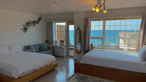 a bedroom with two beds and a view of the ocean at Jeju Stay Haven in Jeju