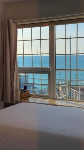 a bedroom with a bed and a large window at Jeju Stay Haven in Jeju