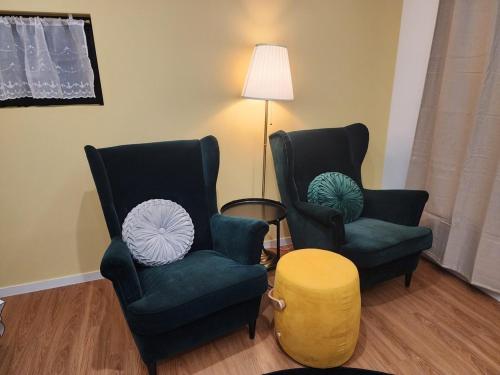 two chairs and a table in a living room at Seogwipo Hineni Private House in Seogwipo