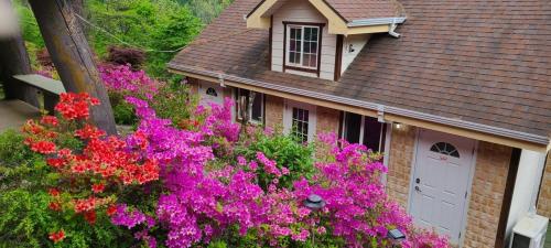 a house with pink flowers in front of it at Wonju Sarichi Land in Forest Pension in Wonju
