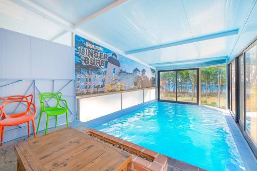 a large indoor swimming pool with a large window at Pool Villa Linderburg in KomsÅm