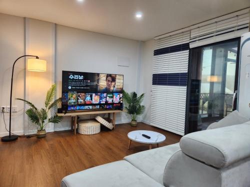 a living room with a couch and a flat screen tv at Paju Heyri Hills Modern House in Paju