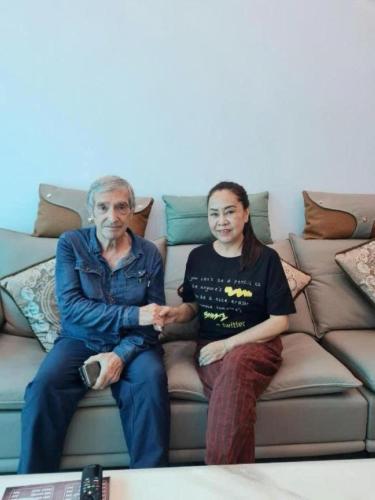 two men are sitting on a couch at Muong Thanh Homestay in Diện Biên Phủ