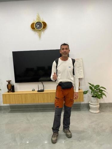 a man standing in a room with a clock on the wall at Muong Thanh Homestay in Diện Biên Phủ