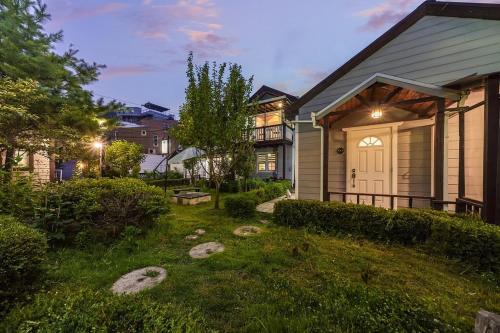 a house with a white door in a yard at Gapyeong Green Star Pension Remodeling, Spa in Gapyeong