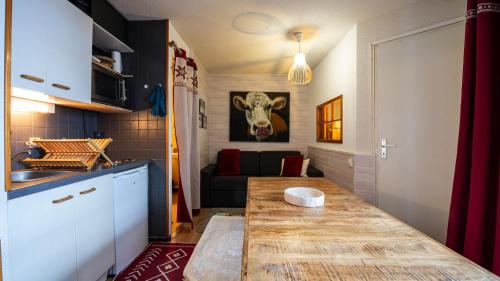 une cuisine avec une table et une tête de vache sur le mur dans l'établissement Grande Neige N 33 - 2P5, à Morillon