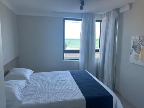 a bedroom with a bed with a view of the ocean at Flat de Frente para o Mar in Natal