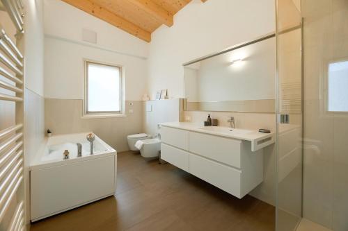 a bathroom with a tub and a sink and a toilet at Casa Montesei di TSS' -Ampio, di classe, vista e posto auto in Pergine Valsugana