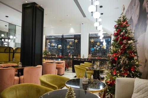 a christmas tree in a restaurant with tables and chairs at Gate Twenty Two Boutique Hotel in Nicosia