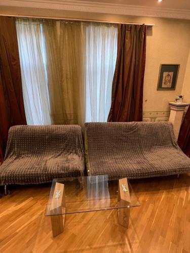 a living room with two beds and a glass table at Cozy apartment in the heart of Baku in Baku