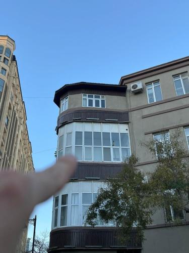 a person is pointing at a tall building at Cozy apartment in the heart of Baku in Baku