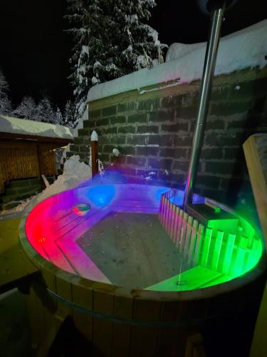 a hot tub with colored lights in the snow at Cabana Denisa in Râu de Mori