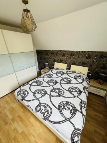 une chambre avec un lit avec une couette noire et blanche dans l'établissement Le BerNid, à Triembach-au-Val