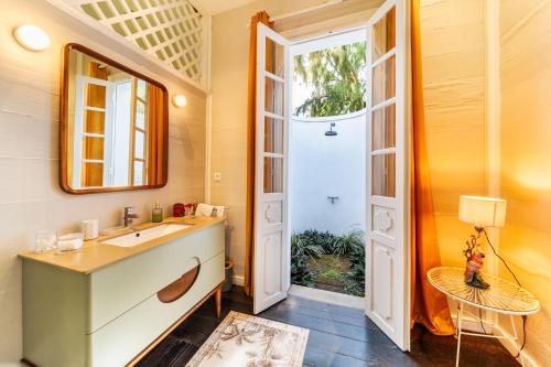 a bathroom with a sink and a mirror at La Garçonniere in Saint-Pierre