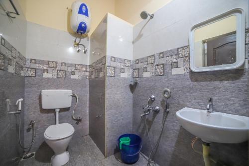 a bathroom with a toilet and a sink at The Springs by Indo Stays in Yedapalli