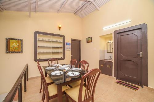 Un comedor con una mesa y sillas y una puerta. en The Springs by Indo Stays, en Yedapalli