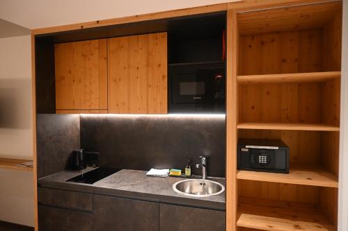 a kitchen with a sink and a microwave at SkiWelt-Lodge Brixen im Thale in Brixen im Thale