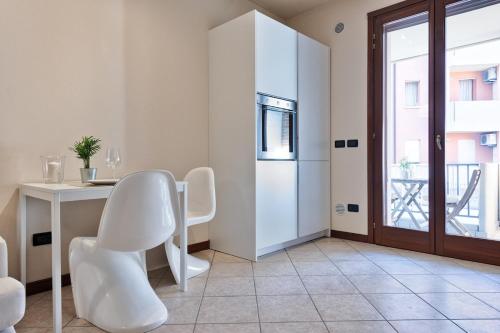 a white dining room with a table and chairs at Perfect home for Venice by train and H-FARM in Quarto dʼAltino