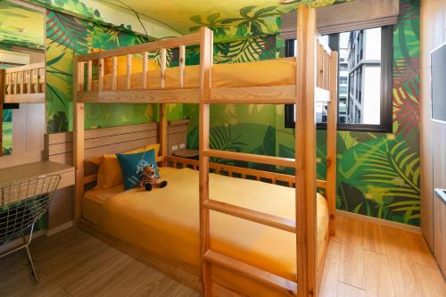 a bunk bed in a kids room with green wallpaper at Cross Vibe Bangkok Sukhumvit in Bangkok