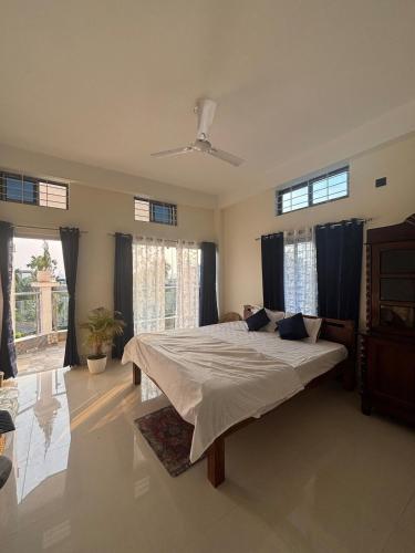 a bedroom with a bed in a room with windows at Choudhury's Stay Barpeta Road in Helāpākari