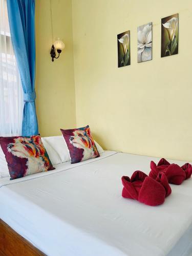 a bed with two red stuffed animals on it at Tanouy Garden in Baan Khai