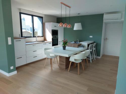une cuisine avec une table et des chaises dans une pièce dans l'établissement Île Grande, Location maison saisonnière chez Dom et Cathy C, à Pleumeur-Bodou